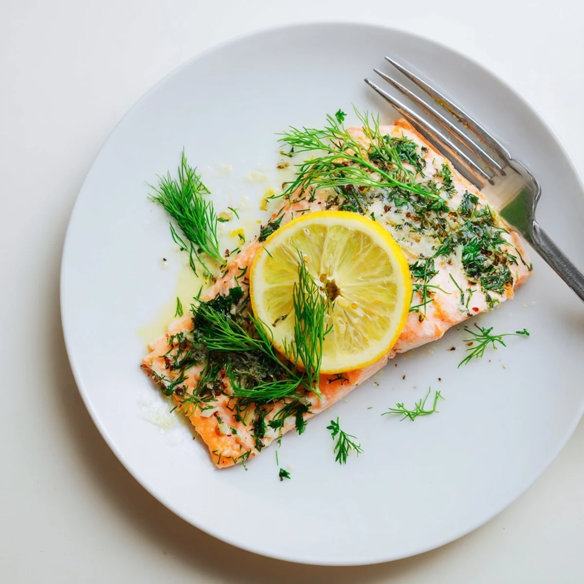Tender Baked Salmon with Lemon and Dill Weed fillets topped with zesty lemon rounds, served alongside roasted vegetables and a light green salad.