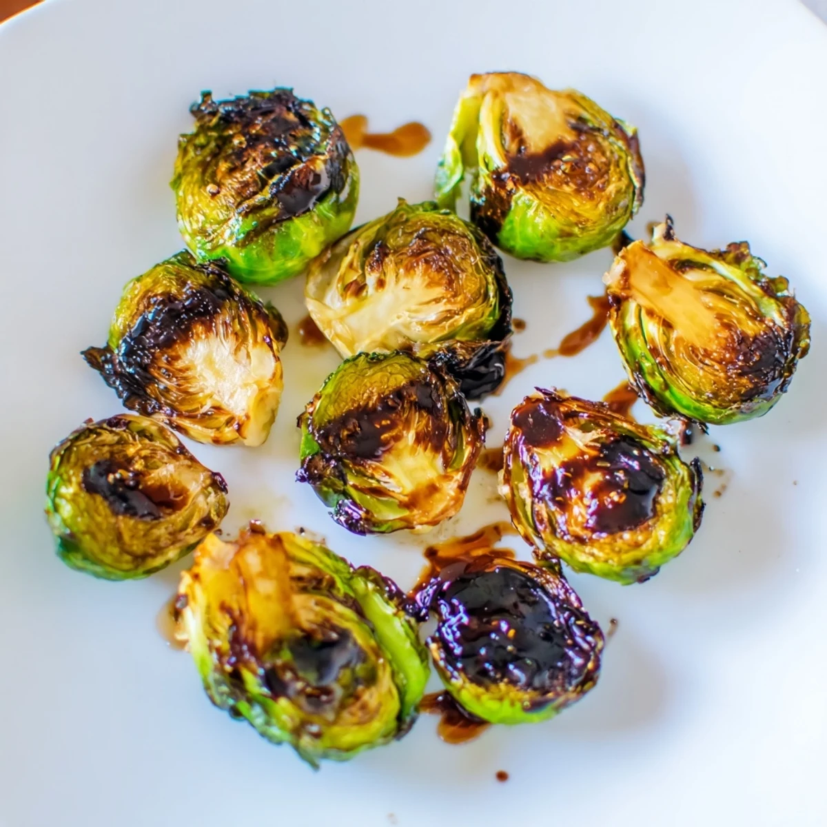 Roasted Brussels sprouts with balsamic glaze served hot, topped with toasted pecans and shaved Parmesan for extra crunch and flavor.