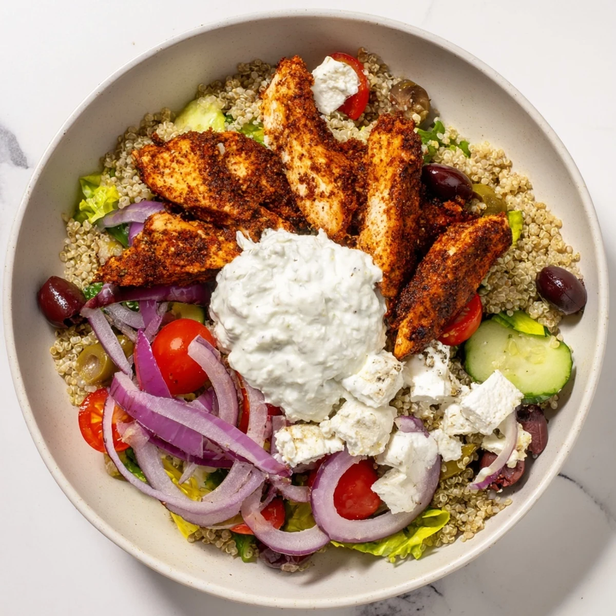 A close-up of Greek Chicken Gyro Bowls with Tzatziki shows charred chicken strips over rice with feta and lemon wedges.