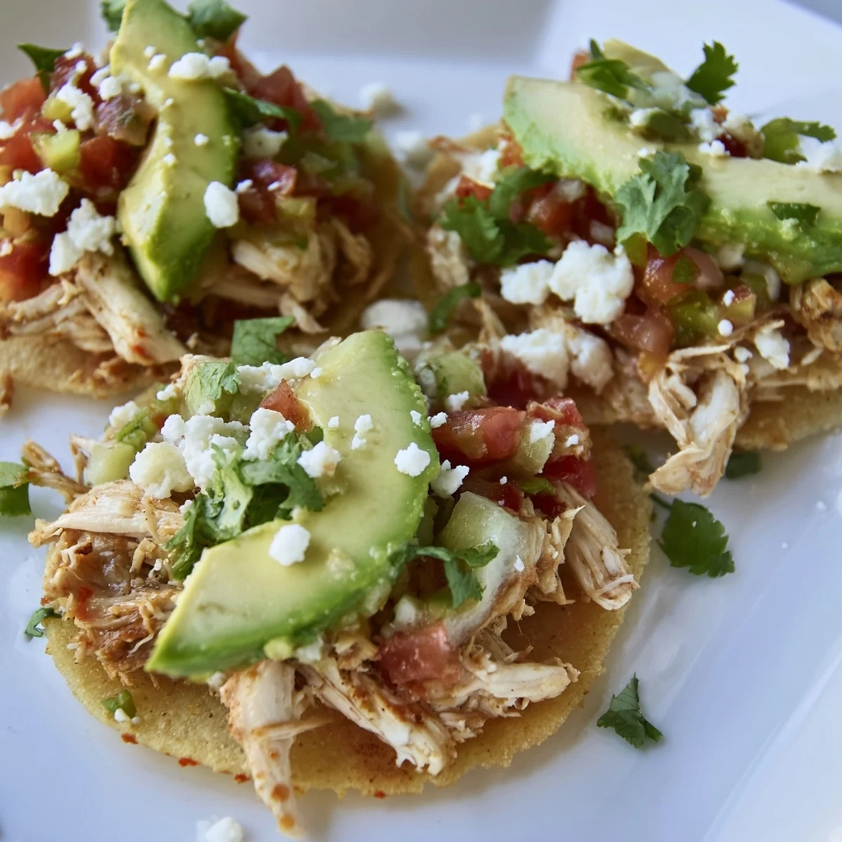 Golden, crunchy mini chicken tostadas topped with fresh pico de gallo and creamy avocado.