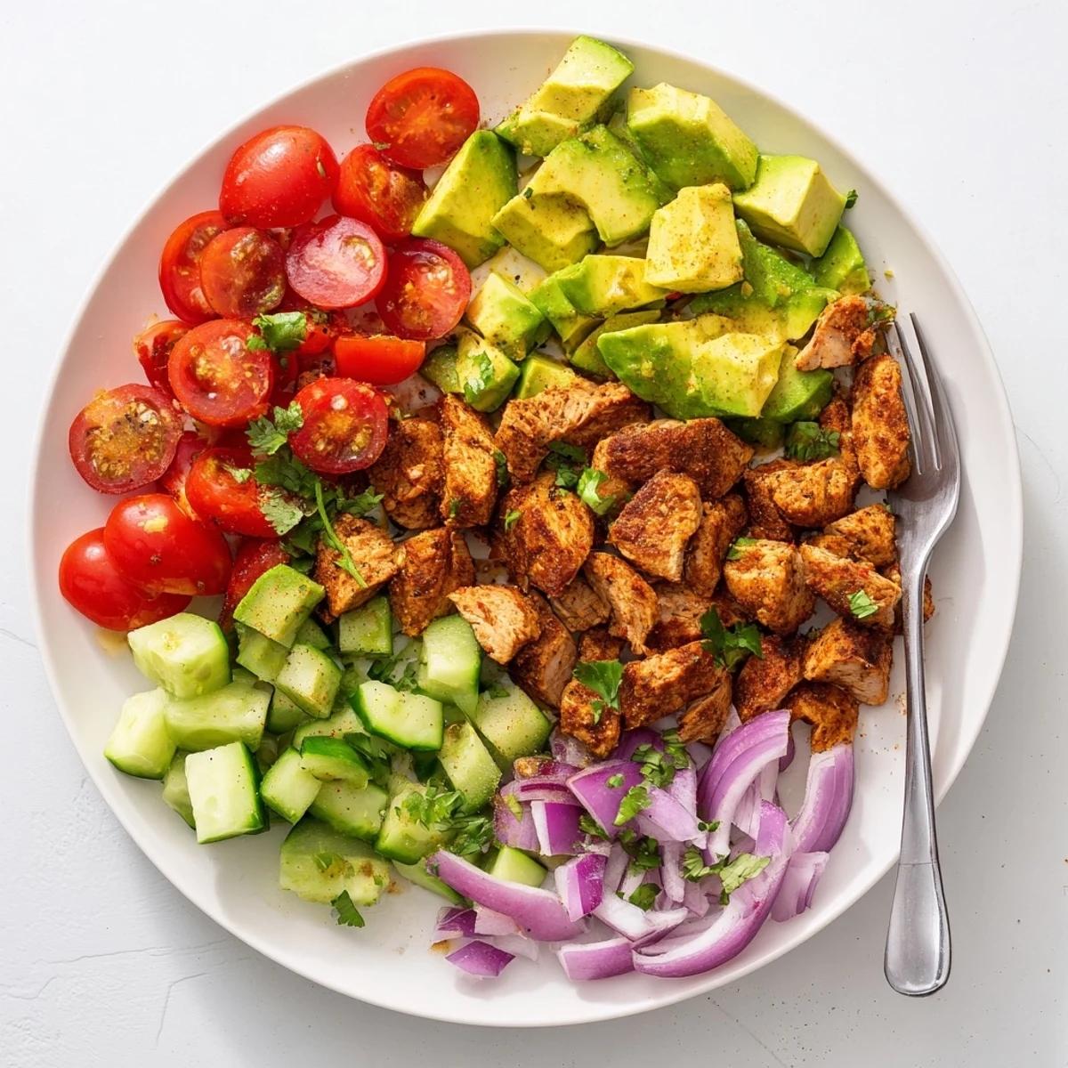 The Avocado Chicken Salad shows grilled chicken pieces mixed with diced avocado and cherry tomatoes on a white plate.