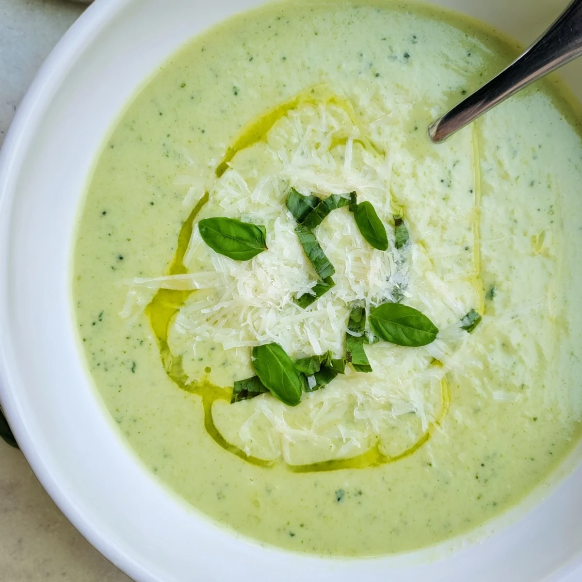 Close-up of smooth homemade Italian broccoli soup served with crusty bread and Parmesan cheese topping