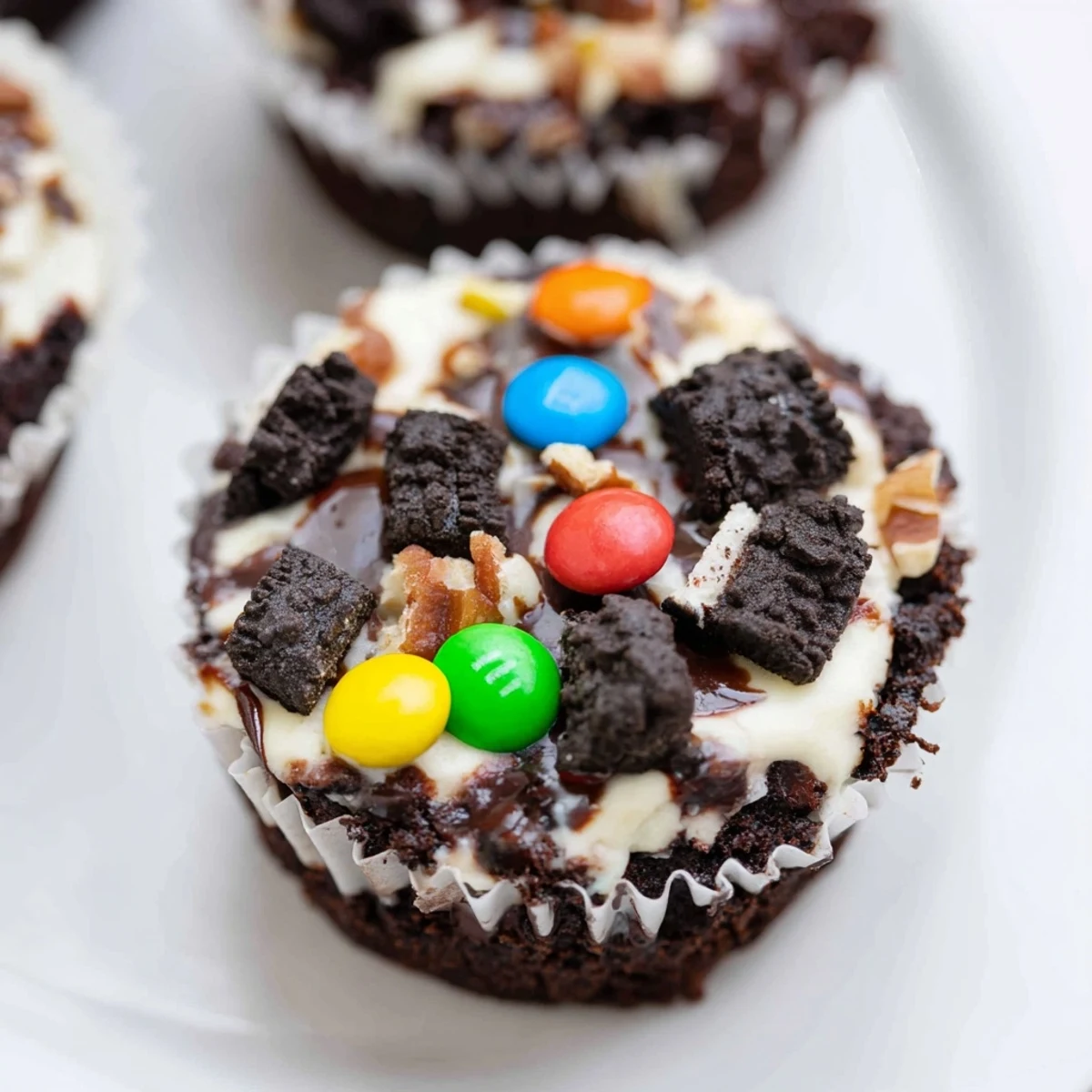 Fudgy loaded brownie cheesecake cups sprinkled with mini chocolate chips and walnuts for parties