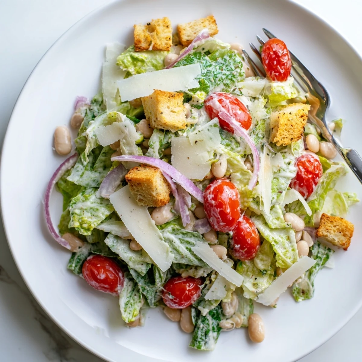 Creamy butter bean Caesar salad featuring protein-rich beans, crisp lettuce, and tangy homemade dressing on a rustic wooden table.