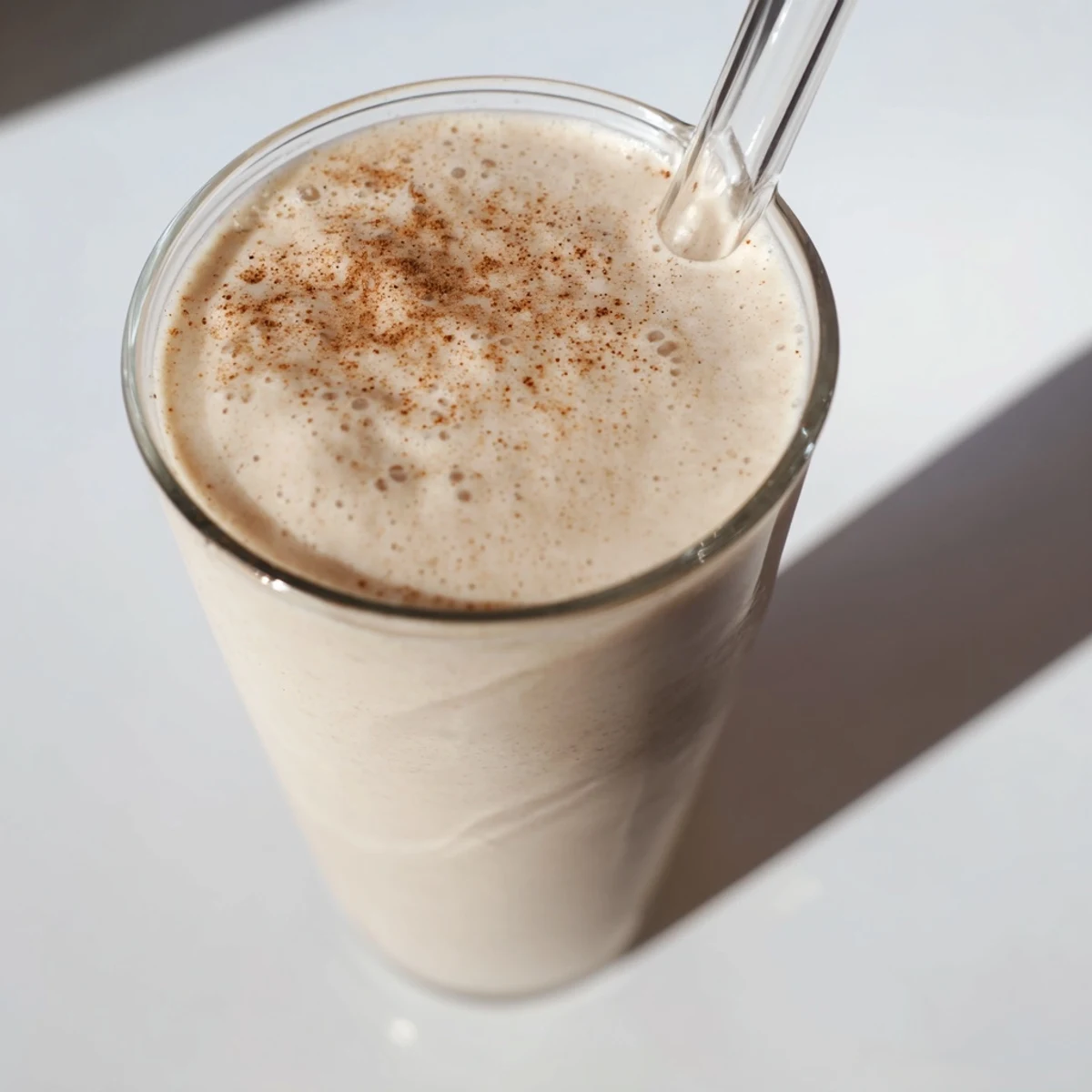 Fresh blended Greek yogurt banana smoothie topped with granola and chia seeds in clear mason jars