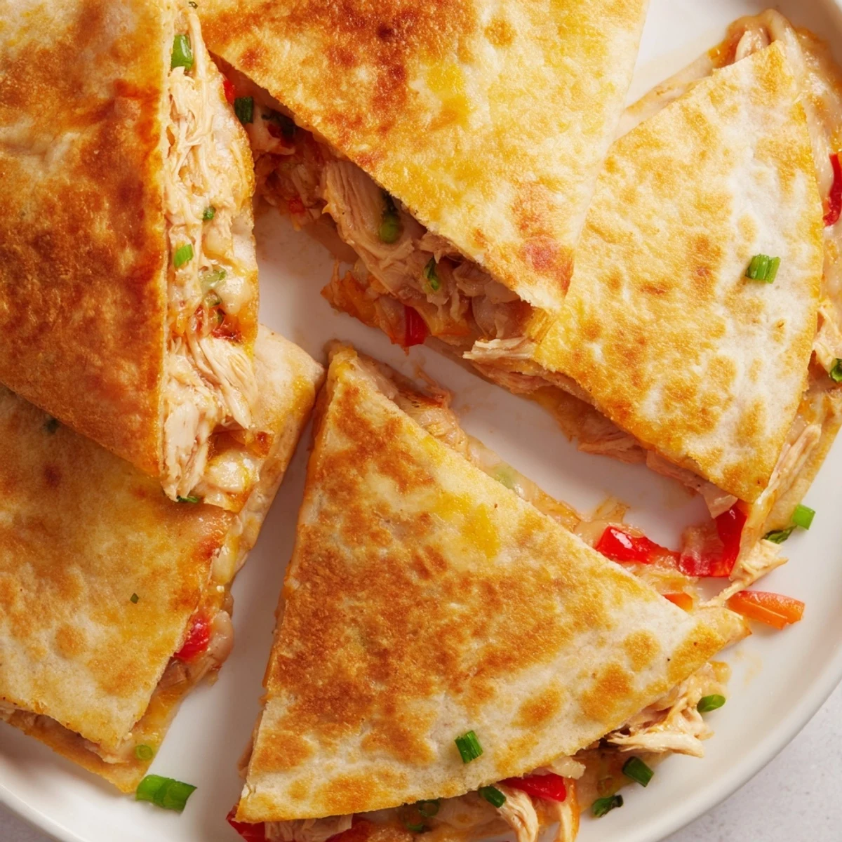 Crispy oven-baked quesadillas stuffed with seasoned shredded chicken and gooey Mexican blend cheese