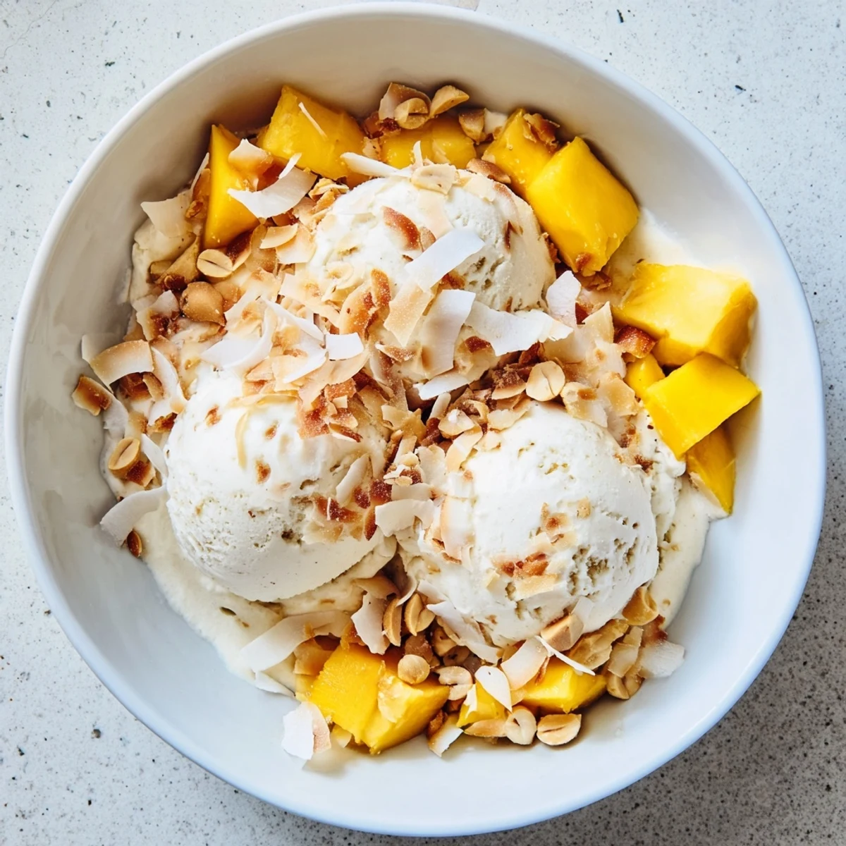 Dairy-free Thai coconut milk ice cream swirled in a glass serving dish with vanilla bean specks visible