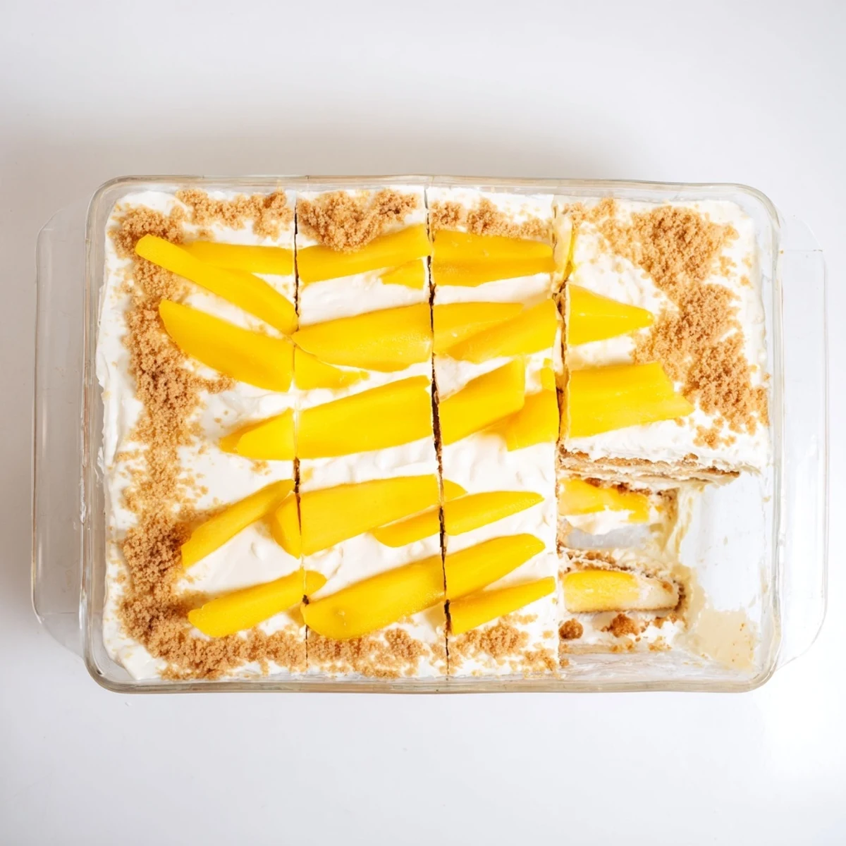 No-bake Filipino Mango Float square served on white plate featuring sweet mangoes and fluffy cream filling