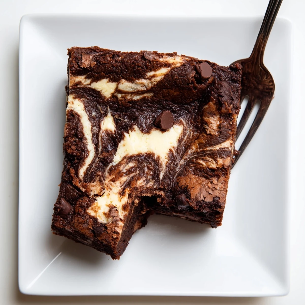 Homemade cheesecake swirled brownies showing rich cocoa batter marbled with sweet cream cheese topping, dusted with powdered sugar