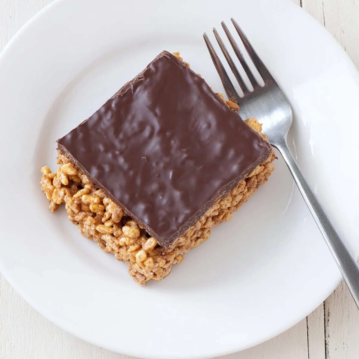 Golden gluten-free honey Chex chocolate peanut butter bars sliced into squares on a white serving plate