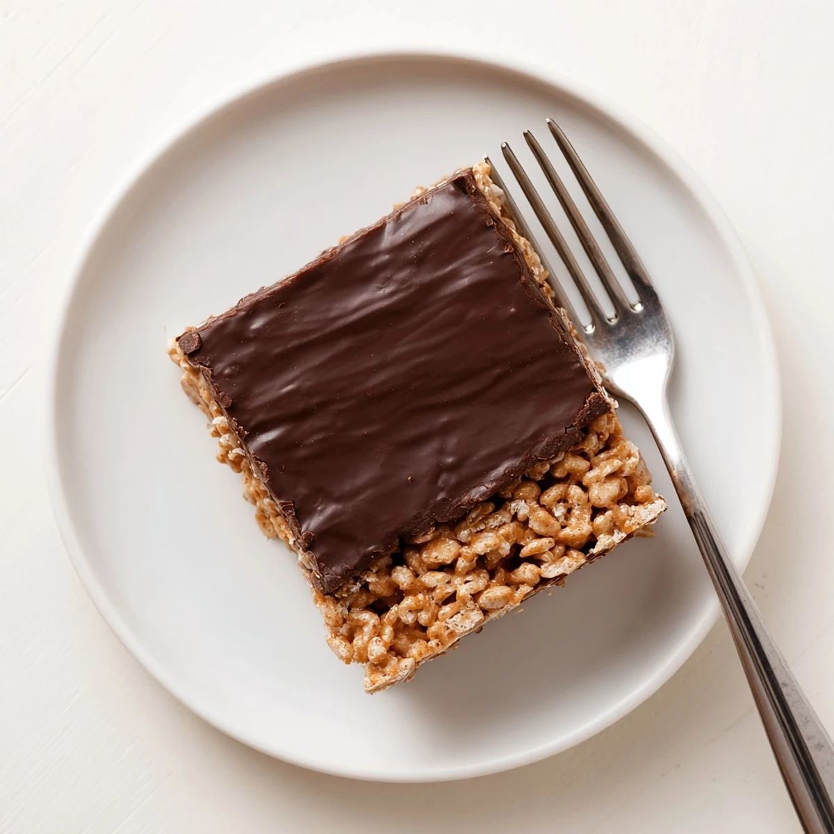 Thick chocolate layer drizzled over crunchy honey Chex peanut butter cereal bars arranged on a rustic wooden board