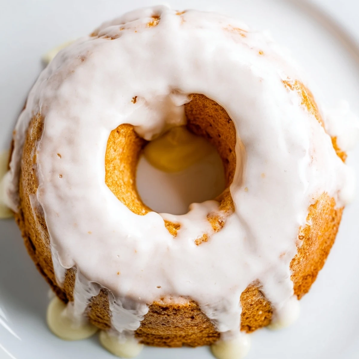 Golden baked Greek yogurt cake donuts topped with sweet vanilla glaze and sprinkles on a wire rack