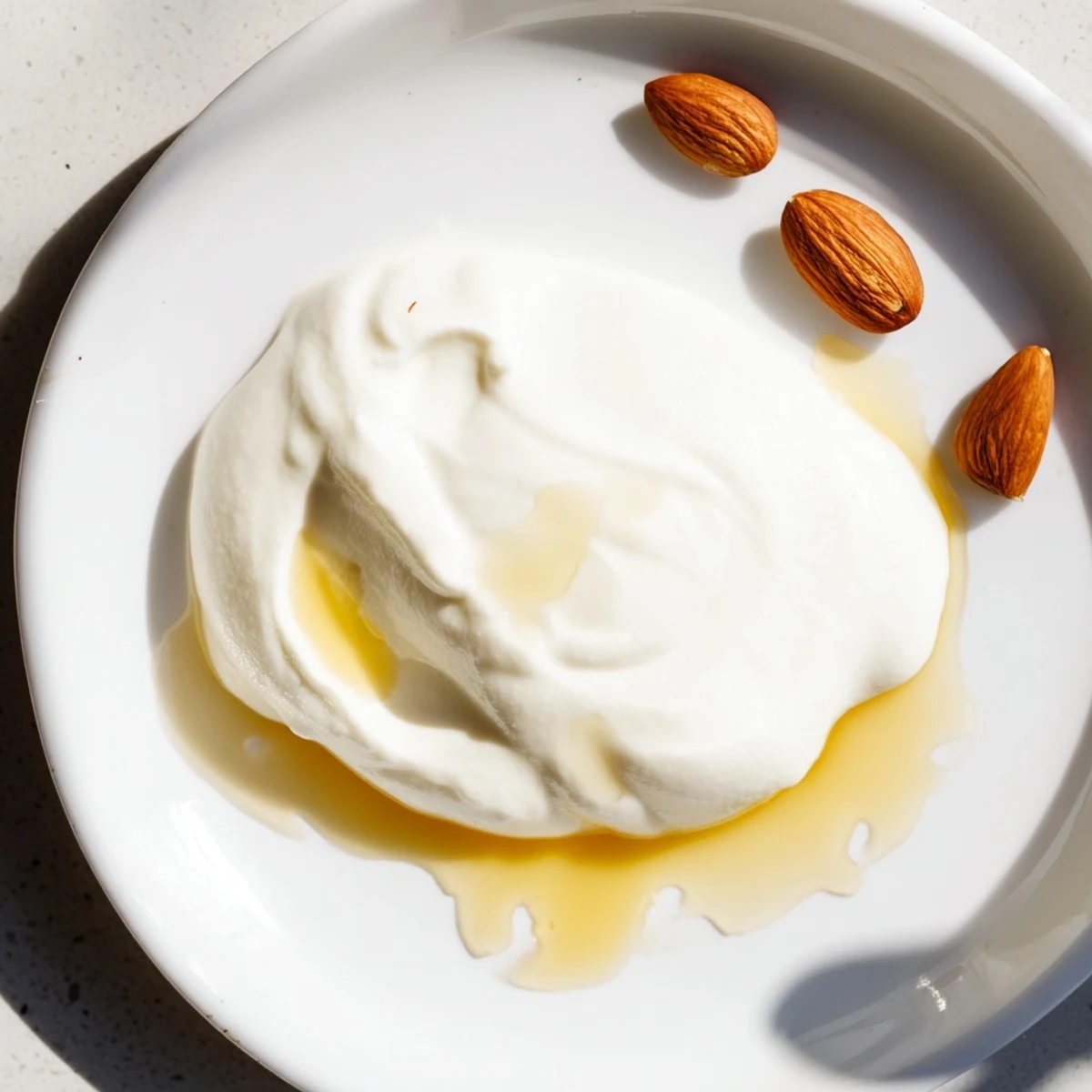 Bowl of tangy Greek yogurt drizzled with golden honey and sprinkled with crunchy granola for breakfast