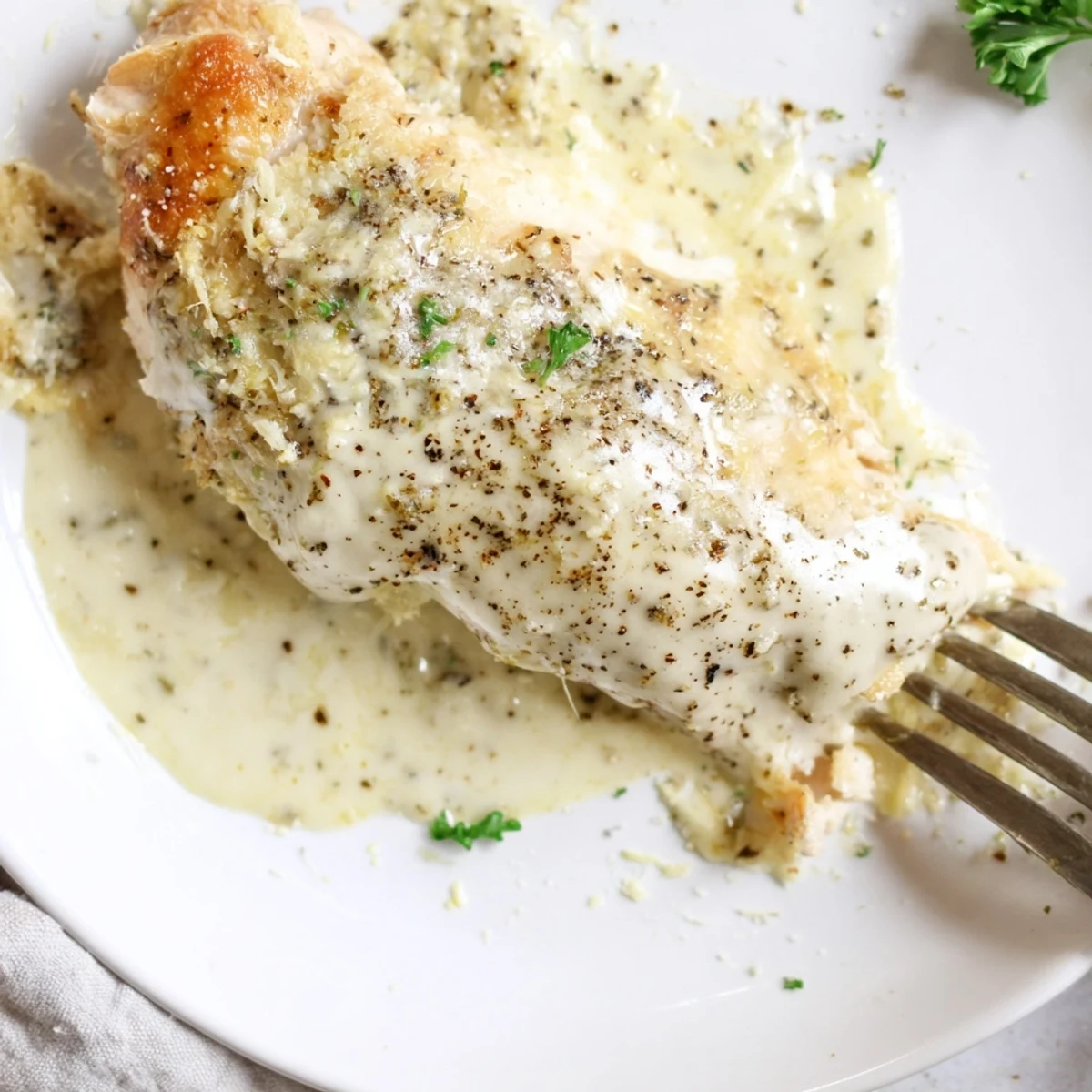 Golden baked Caesar Chicken Recipe with creamy parmesan sauce, steaming and aromatic