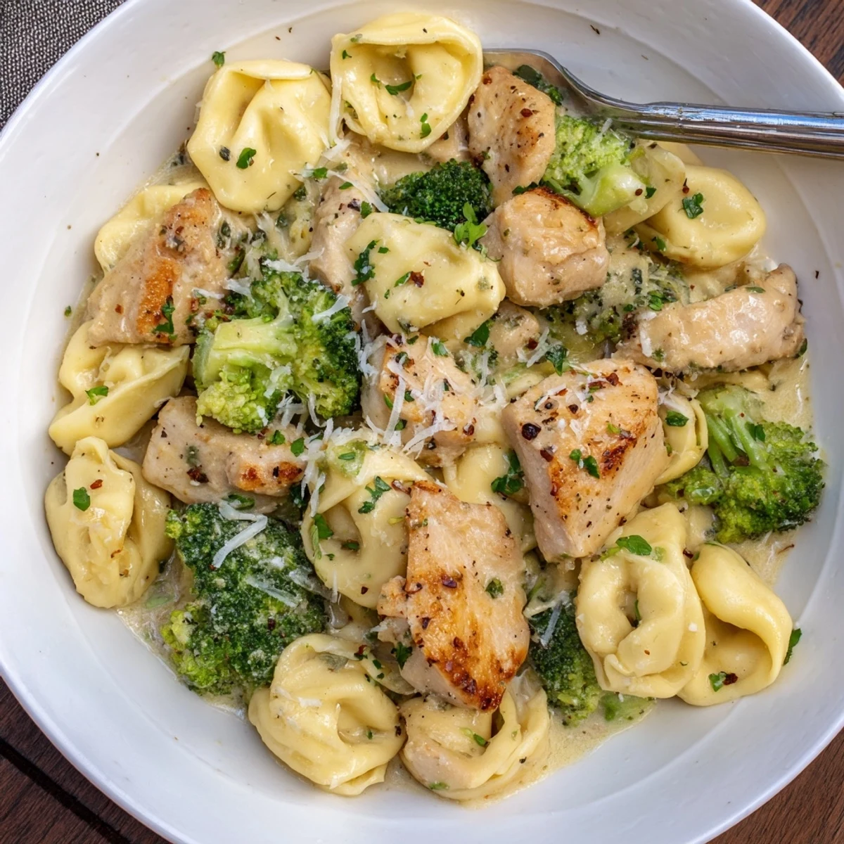 Creamy Garlic Parmesan Tortellini Chicken Broccoli Recipe plated steaming, fragrant garlic sauce, Parmesan sprinkle