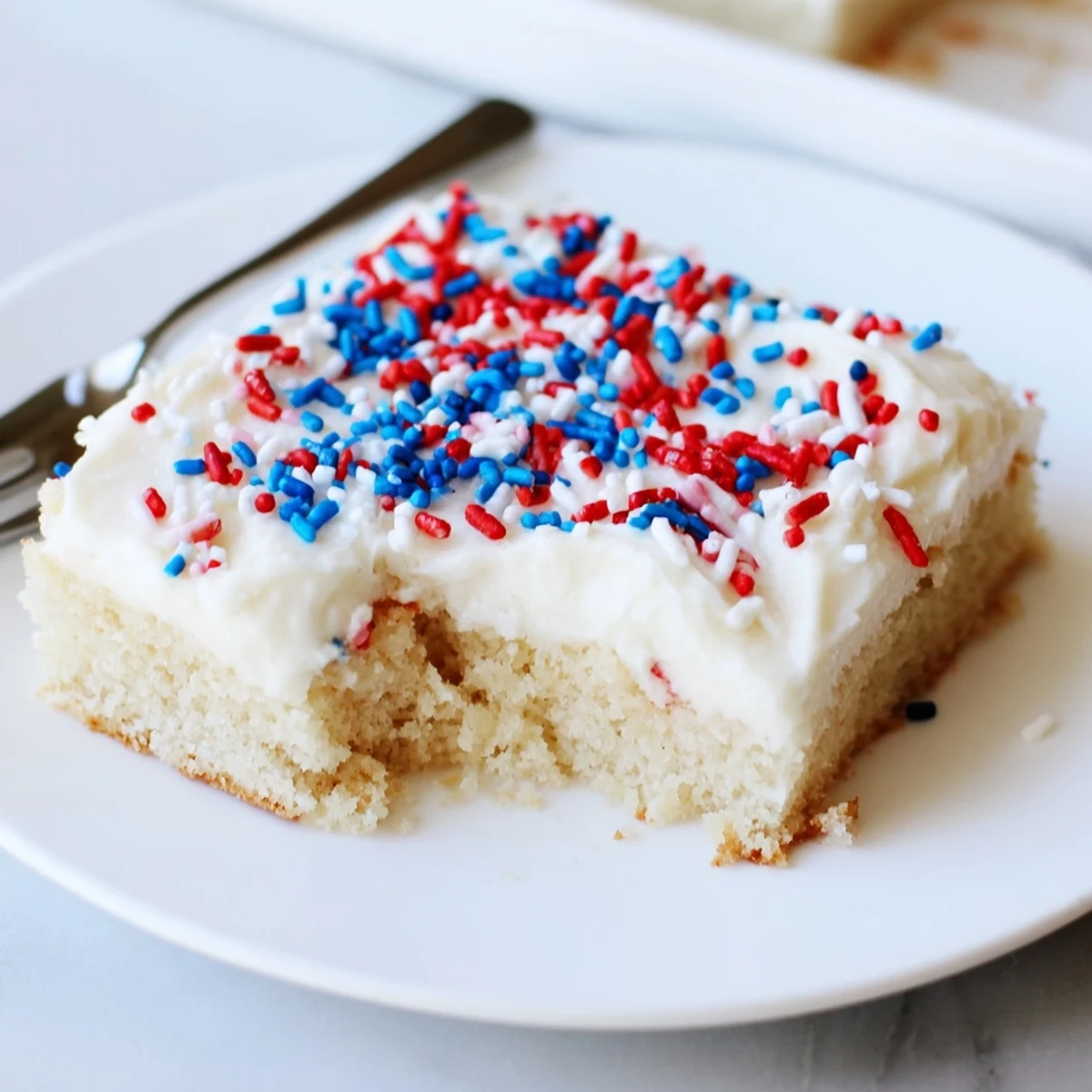 4th Of July Sugar Cookie Bars Recipe topped with creamy vanilla frosting and sprinkles.