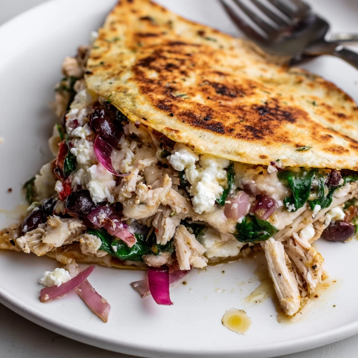 Juicy marinated chicken in Greek Chicken Quesadillas oozing cheese and olives