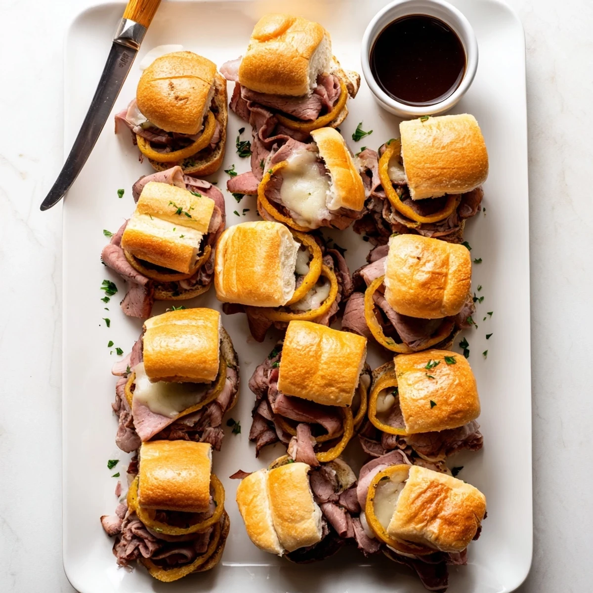 Baked French dip sliders topped with melted cheese pairs perfectly with warm beef broth for sandwich dipping