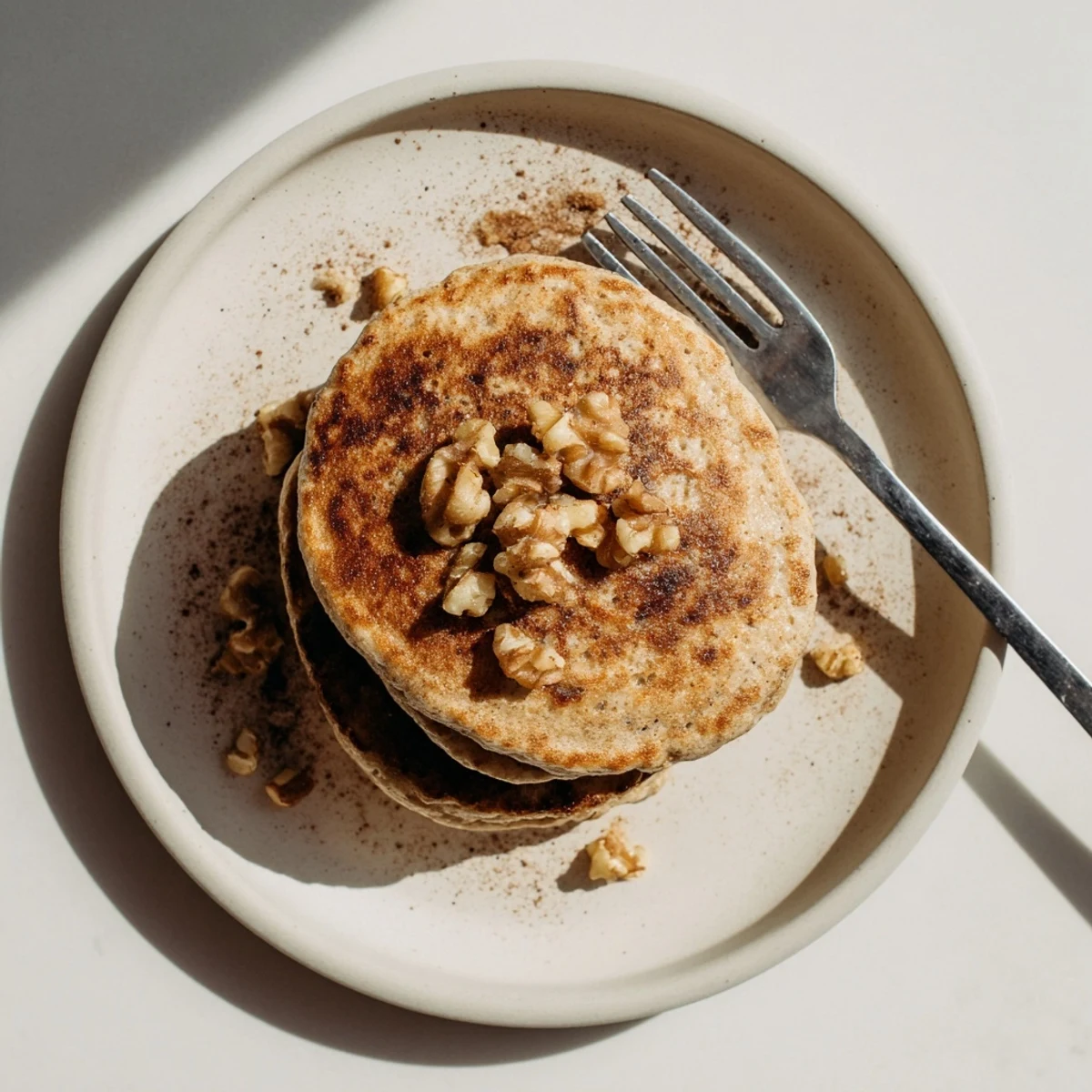 Fluffy golden protein banana pancakes stacked high with fresh banana slices and maple syrup drizzle