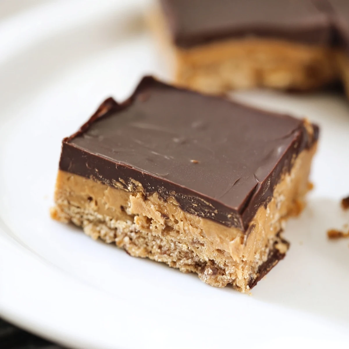 No-bake peanut butter bars showcase smooth chocolate frosting over a crumbly graham cracker base