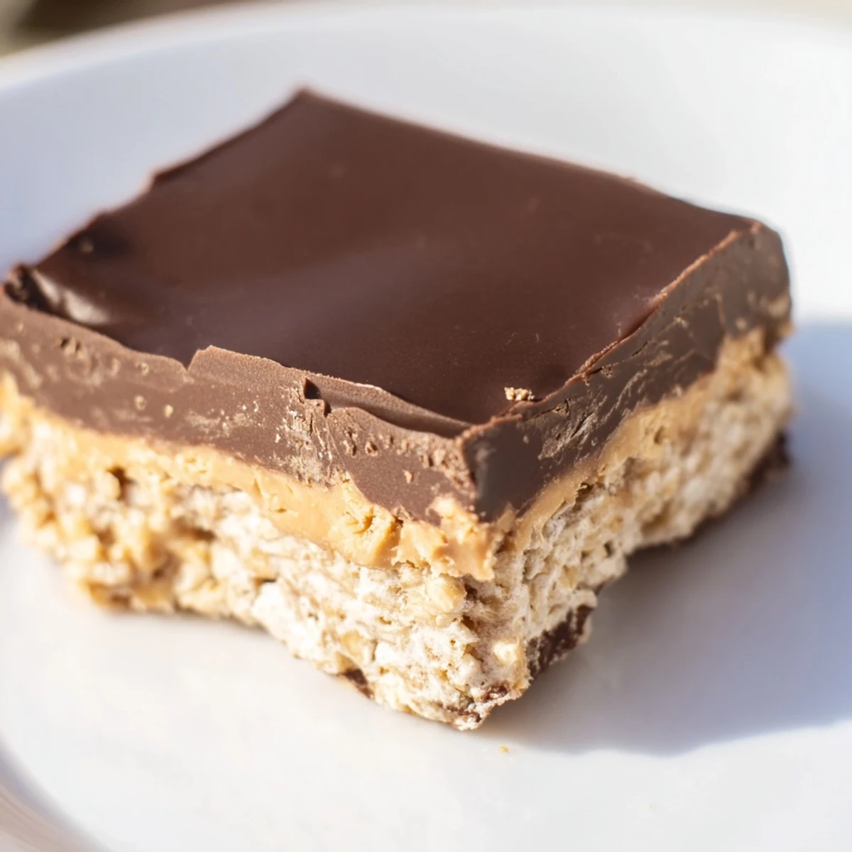 Rich peanut butter bars with glossy chocolate topping arranged on a serving platter for dessert