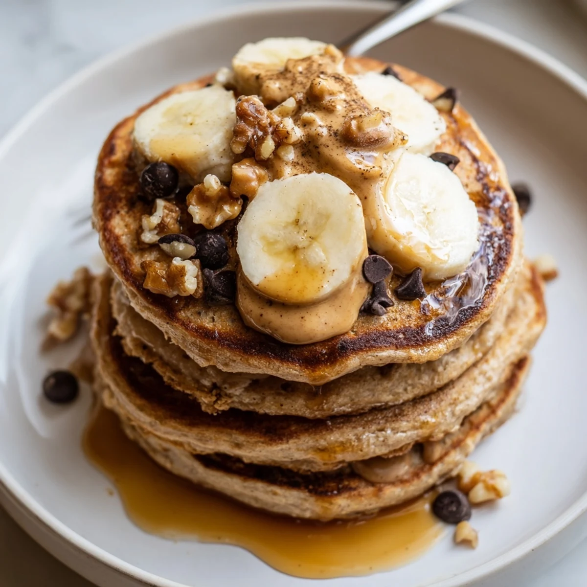 Warm Protein Banana Pancakes stacked, golden edges, drizzled maple syrup and berries