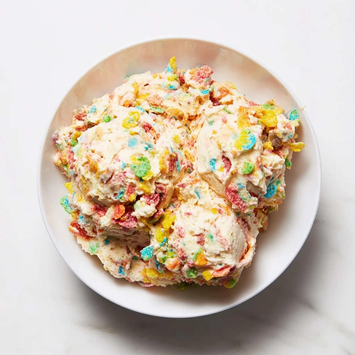 Creamy Fruity Pebbles Cereal Frosting with rainbow crunch, ideal for parties