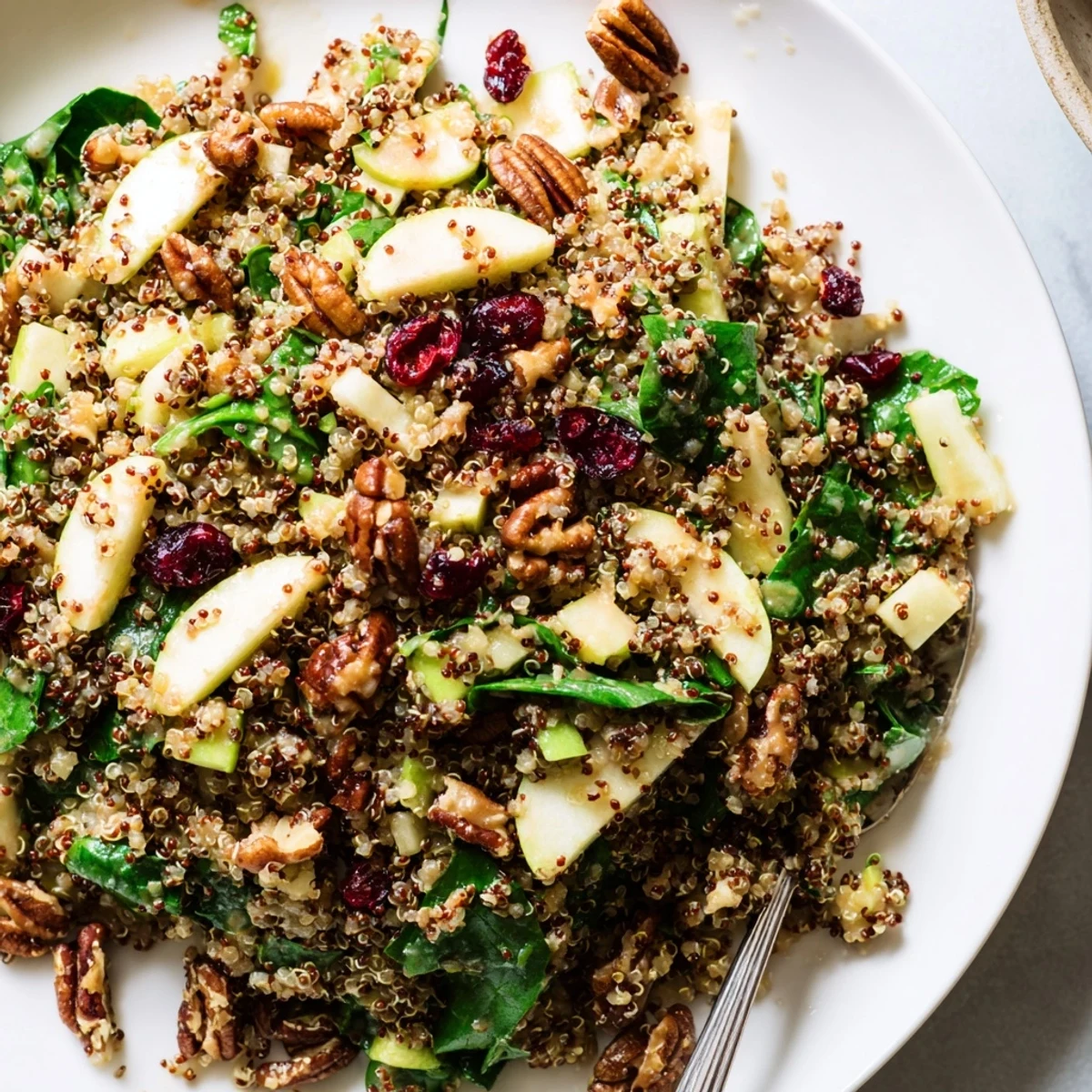 A vibrant bowl of Honey Mustard Quinoa Apple Salad drizzled with creamy golden dressing