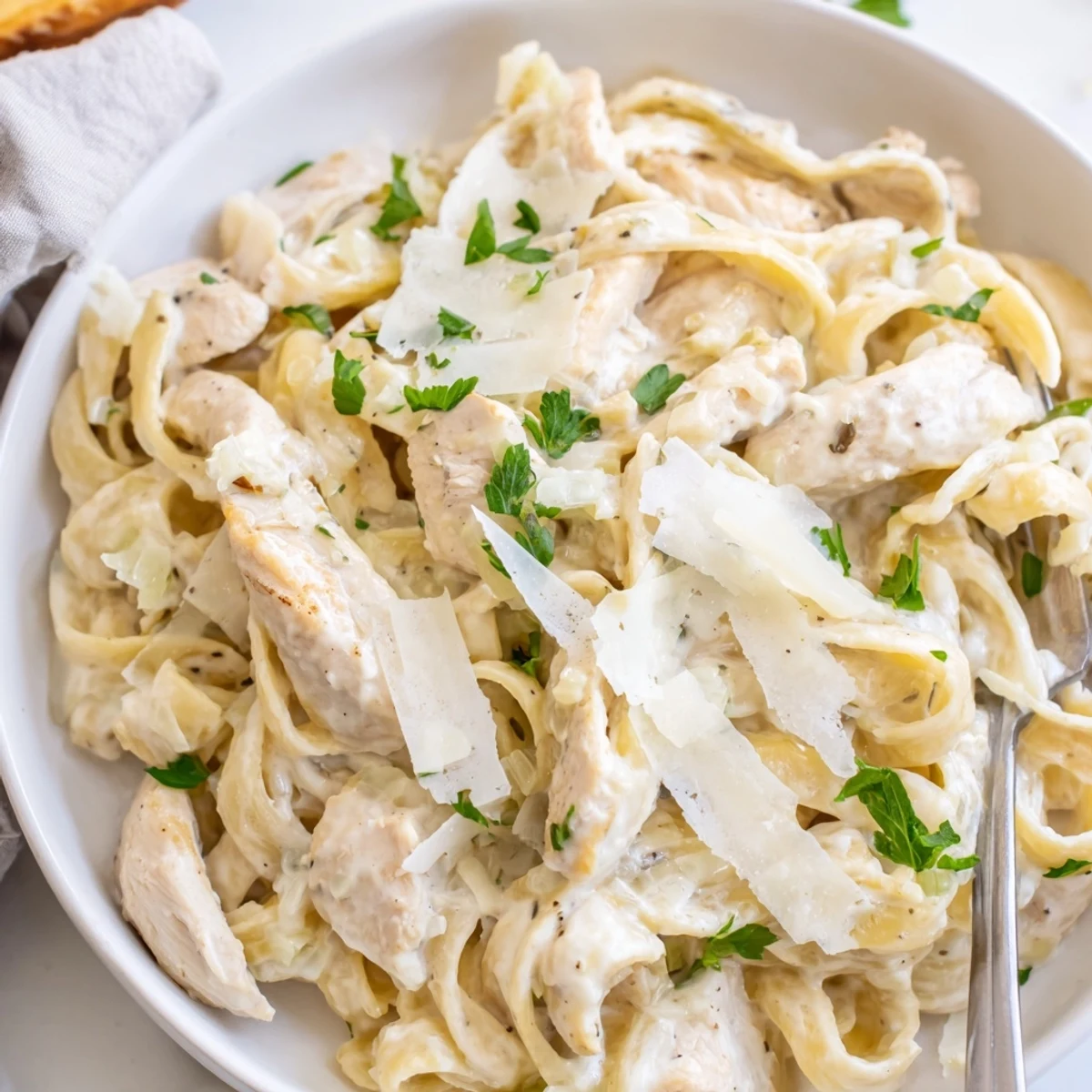 Creamy garlic Parmesan chicken pasta topped with fresh parsley and extra cheese
