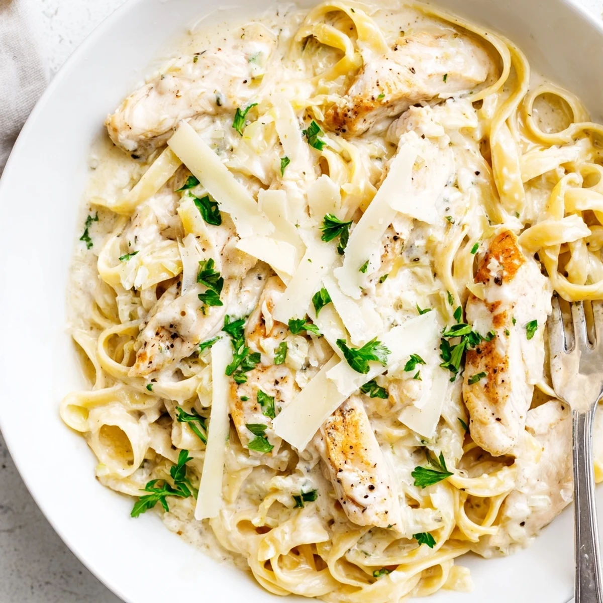 Tender sliced chicken over fettuccine coated in a velvety garlic Parmesan cream sauce