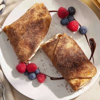Creamy cheesecake chimichangas fresh from the fryer drizzled with rich chocolate sauce