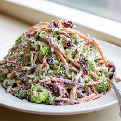 Colorful broccoli slaw tossed with shredded carrots, red cabbage, and creamy dressing